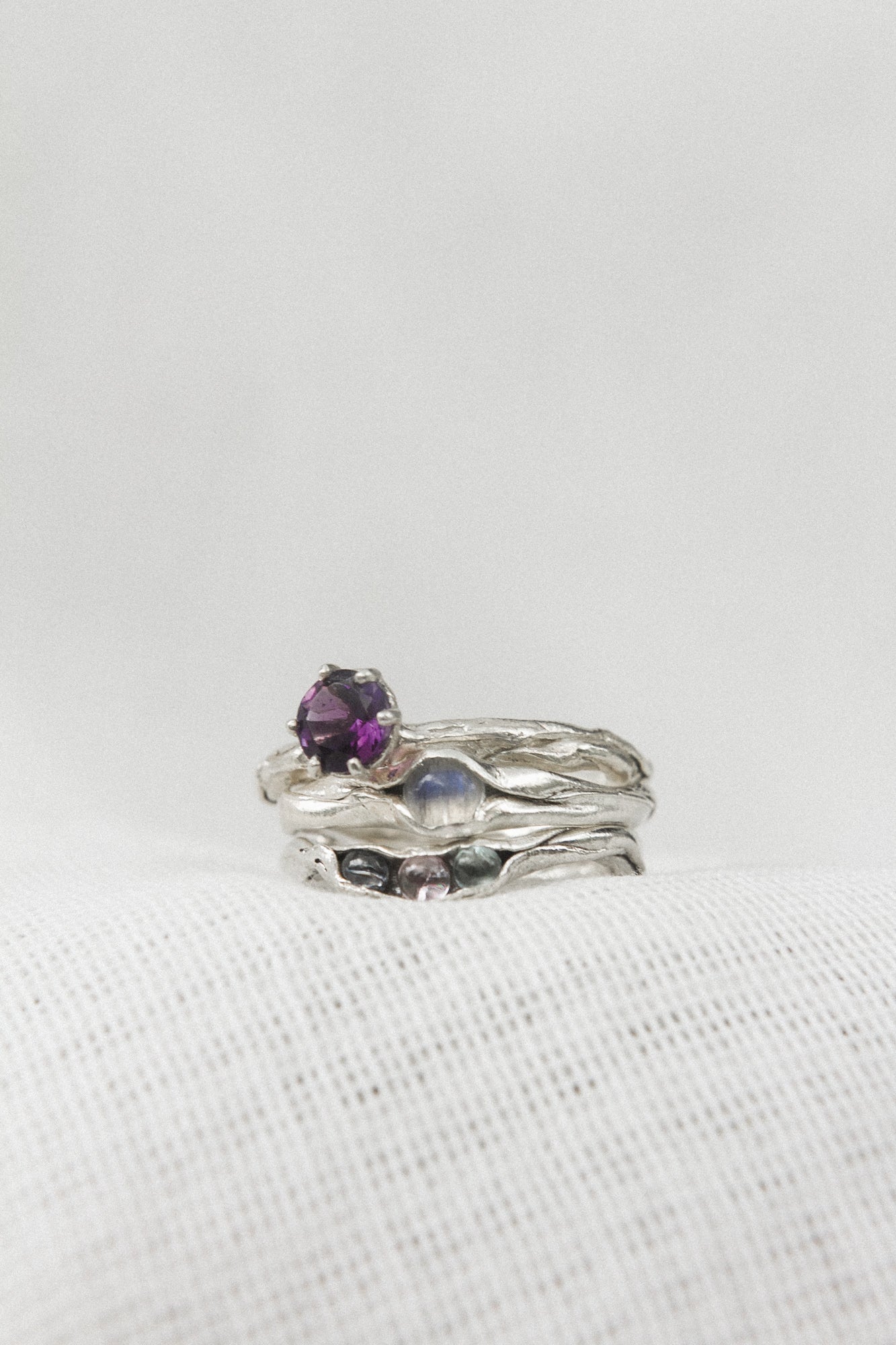 Anillo de amatista en plata esterlina combinado con dos bandas adicionales texturizadas de plata, sobre fondo blanco