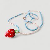 Collar Fresa dispuesto verticalmente sobre fondo blanco, mostrando cuentas alternadas turquesas y blancas y un colgante de fresa de vidrio rojo.