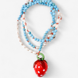 Coiled Strawberry Necklace on a white background, showcasing multiple loops of turquoise and white beads with the red glass strawberry pendant in view