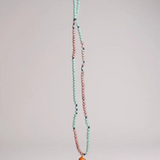 Collar Naranja extendido verticalmente sobre fondo blanco, mostrando la cadena completa de cuentas en verde menta y rosa y el colgante de media luna naranja en la parte inferior.