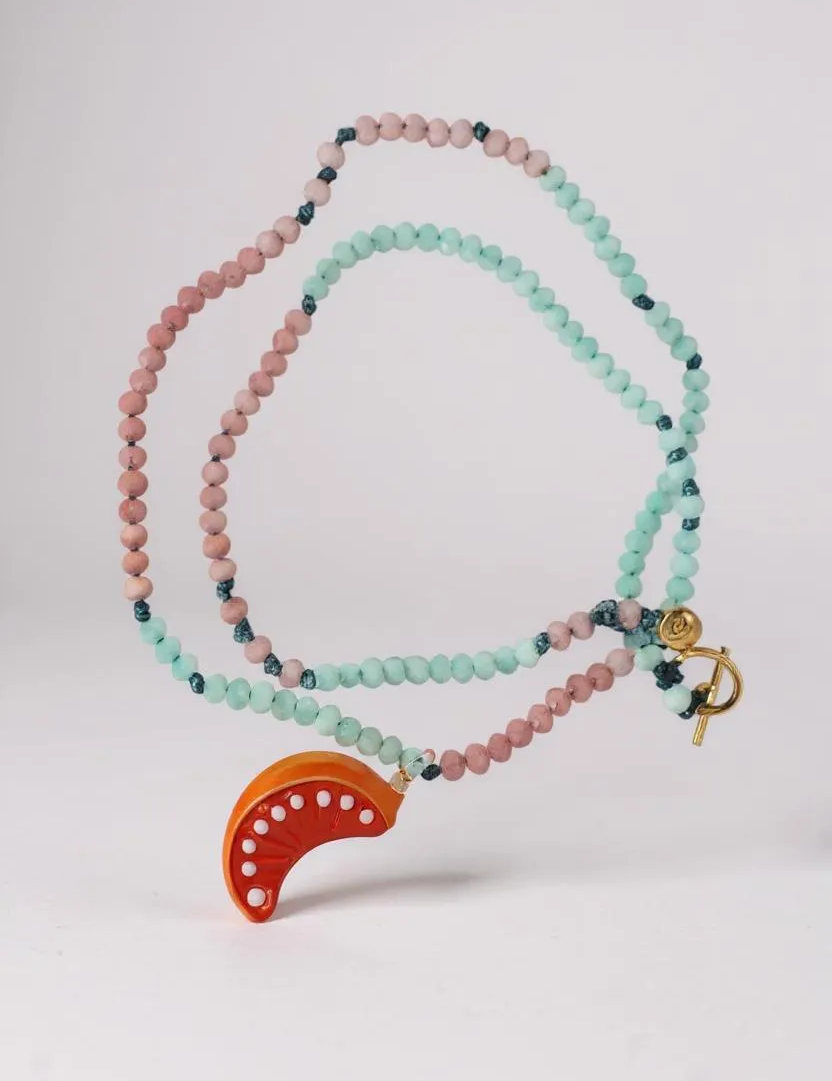 Disposición plana del Collar Naranja sobre fondo blanco, con cuentas alternadas en verde menta y rosa y un colgante de media luna naranja brillante.