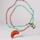 Disposición plana del Collar Naranja sobre fondo blanco, con cuentas alternadas en verde menta y rosa y un colgante de media luna naranja brillante.