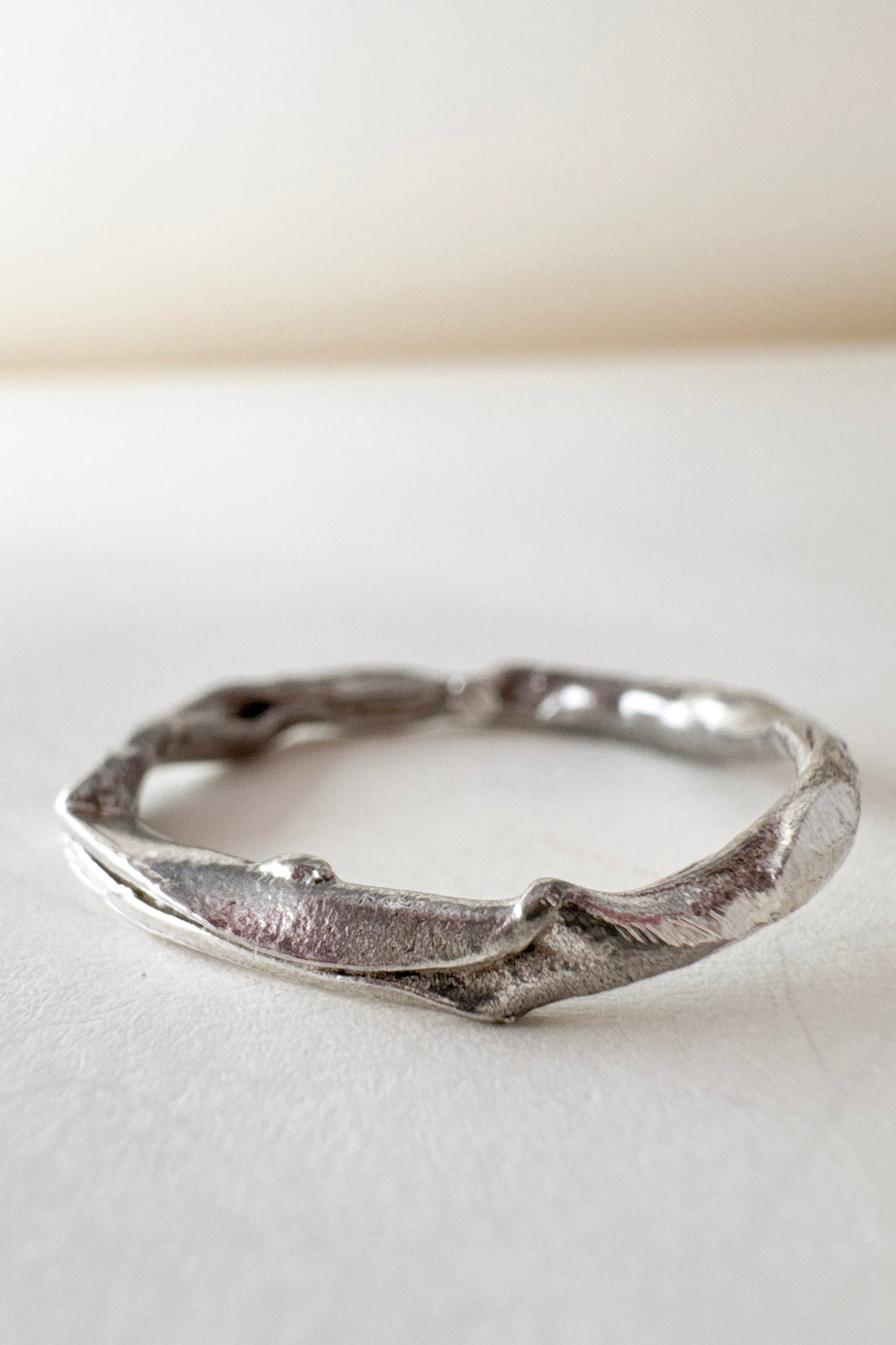 Vista superior del anillo de plata hecho a mano con diamantes de laboratorio, sobre fondo blanco.