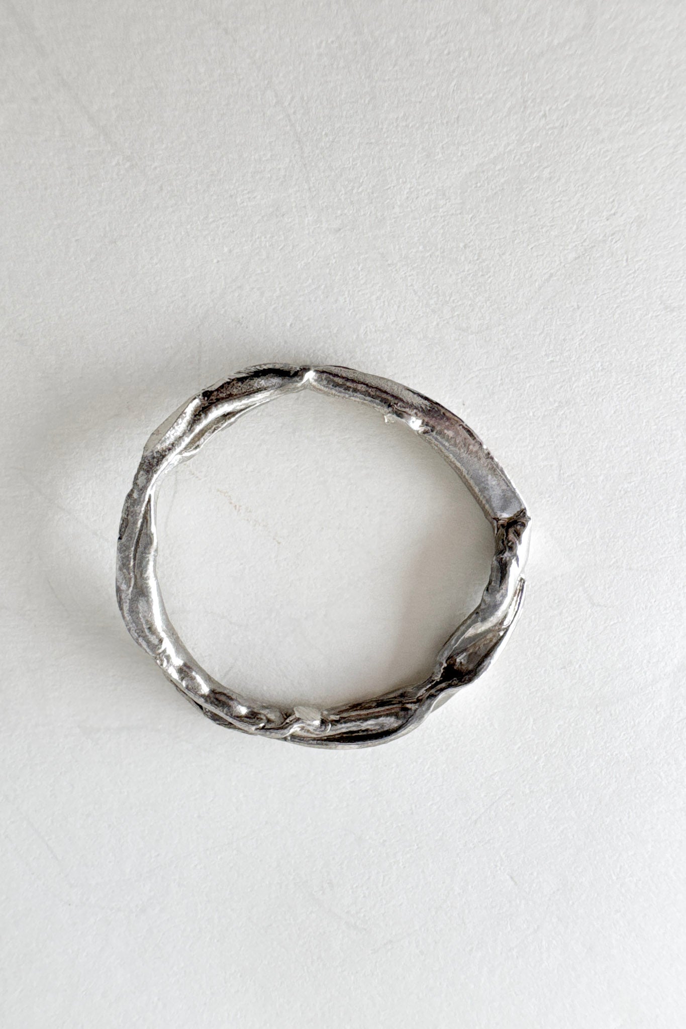 Anillo de plata visto desde arriba, mostrando su forma circular y textura orgánica con pequeños diamantes de laboratorio.