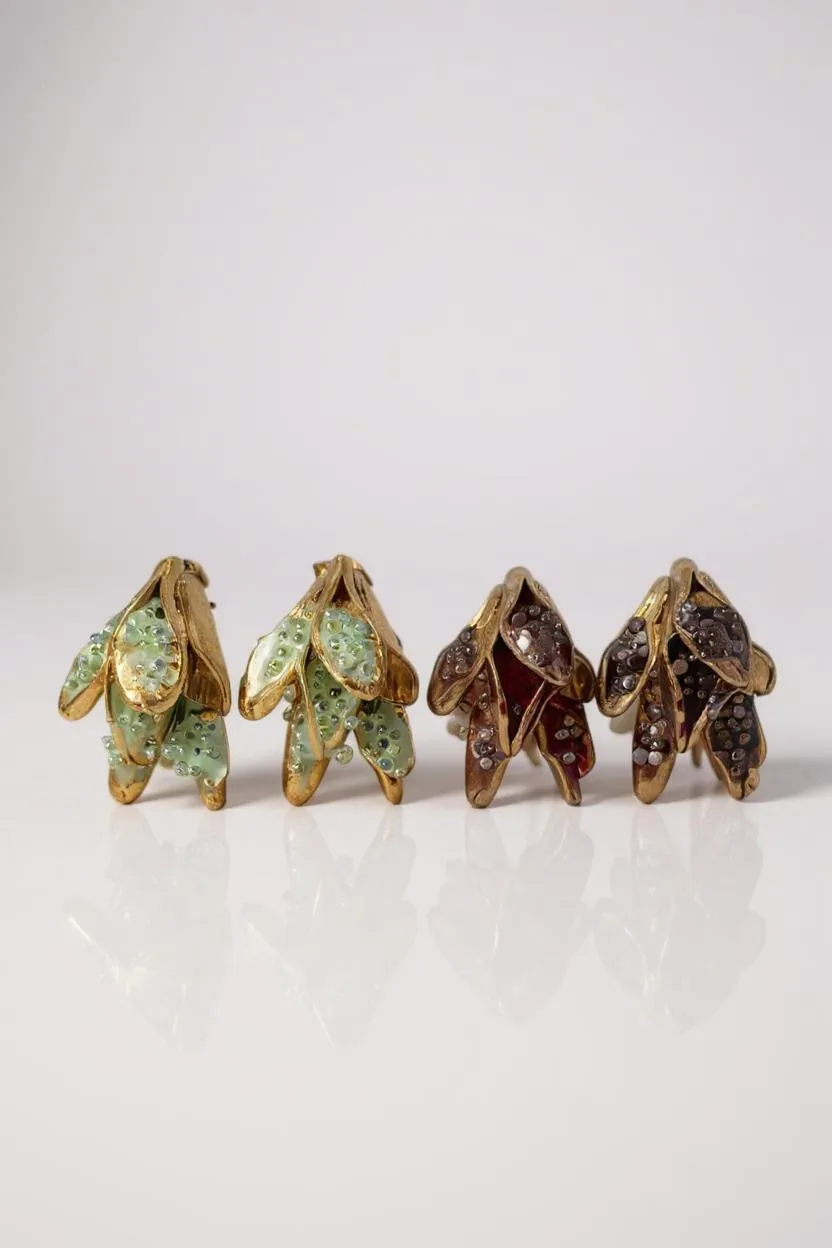 Disposición plana de cuatro aretes Topos Nebula Mini en forma de hoja alineados sobre fondo blanco: dos pintados a mano en verde y dos en rust, cada uno con granulación de vidrio y montura de bronce bañado en oro.