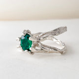 Vista diagonal del anillo de plata esterlina con esmeralda de laboratorio, resaltando la banda texturizada artesanal.