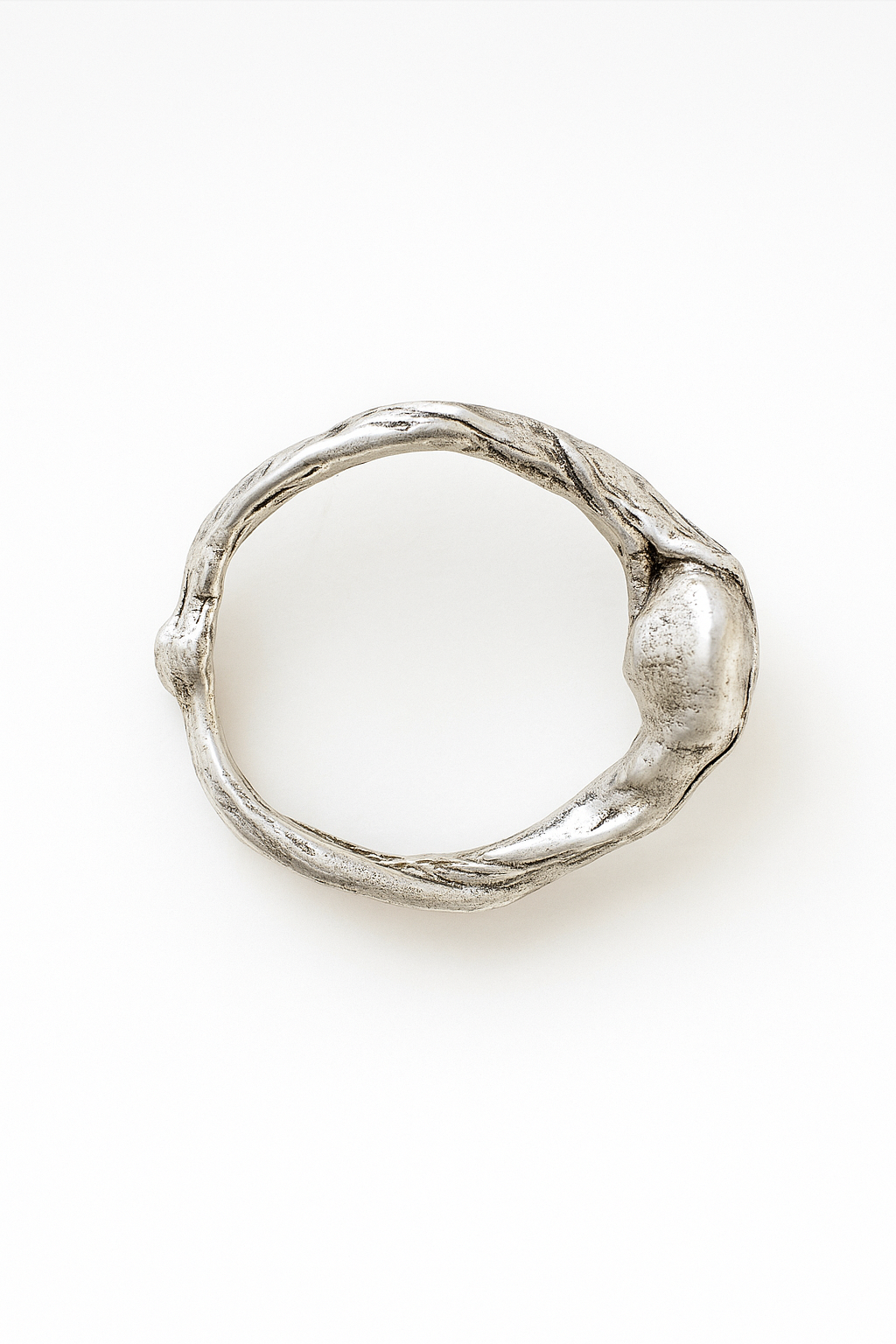 Anillo de plata esterlina con piedra del sol puesto en una mano, fotografiado sobre fondo gris claro