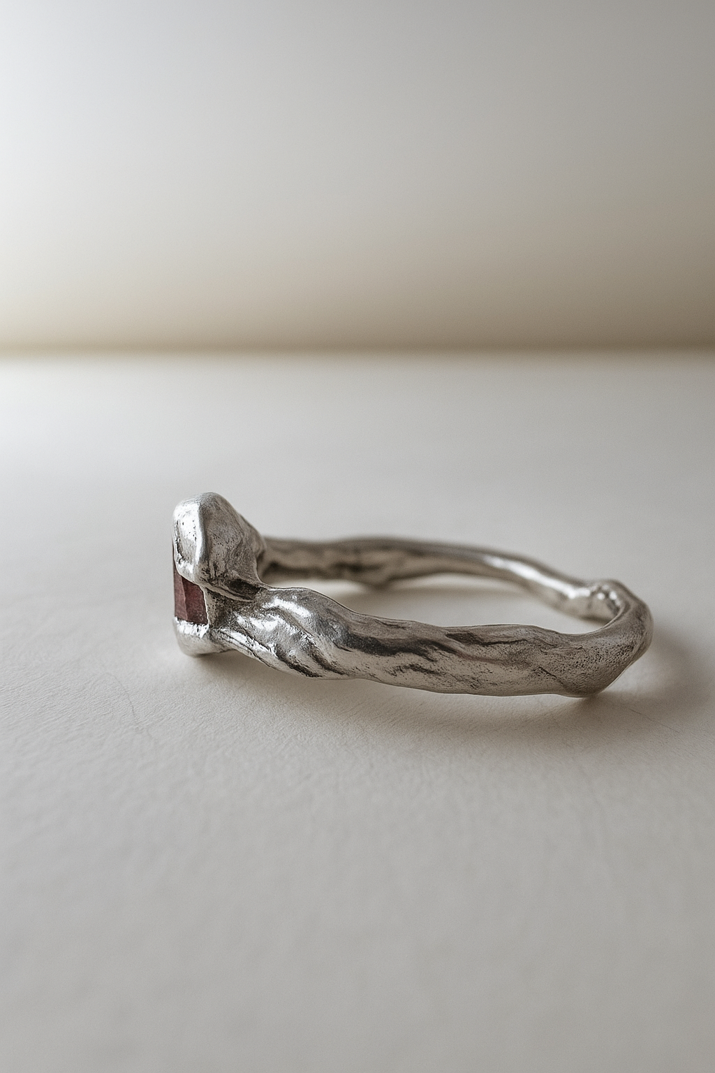 Vista lateral del anillo de plata esterlina con piedra del sol resaltando los contornos naturales de la banda.