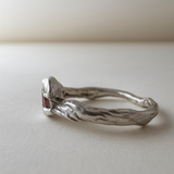 Vista lateral del anillo de plata esterlina con piedra del sol resaltando los contornos naturales de la banda.