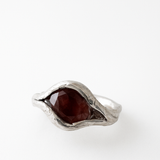 Primer plano del anillo de plata esterlina con piedra del sol ovalada engastada de forma orgánica en la banda, visto desde arriba.