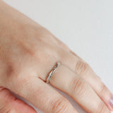 Anillo Nido en plata esterlina con diamante de laboratorio puesto en una mano, fotografiado sobre superficie neutra.