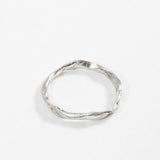 Vista superior del Anillo Nido en plata esterlina mostrando el pequeño diamante incrustado y su forma circular orgánica.