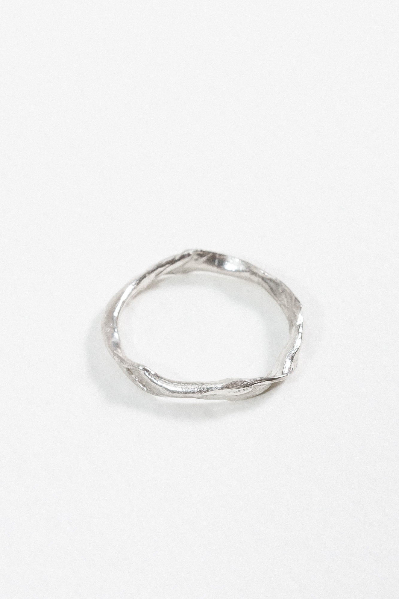 Vista superior del Anillo Nido en plata esterlina mostrando el pequeño diamante incrustado y su forma circular orgánica.