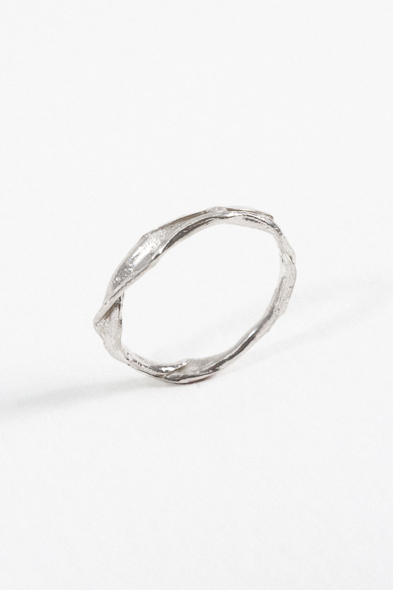 Perfil lateral del Anillo Nido artesanal en plata esterlina con diamante de laboratorio incrustado, sobre fondo blanco.