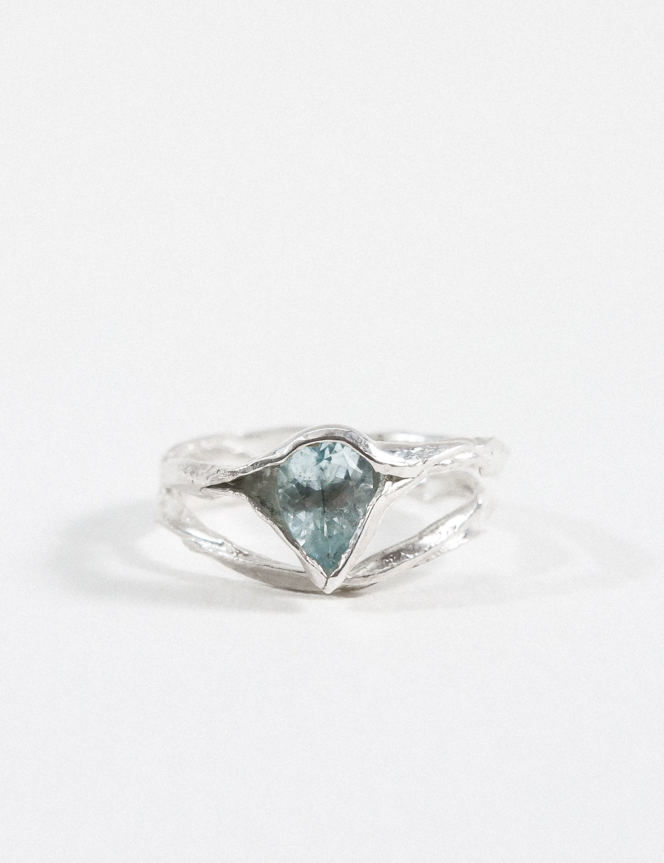 Anillo de plata esterlina con una piedra de aguamarina, mostrado de frente sobre fondo blanco.
