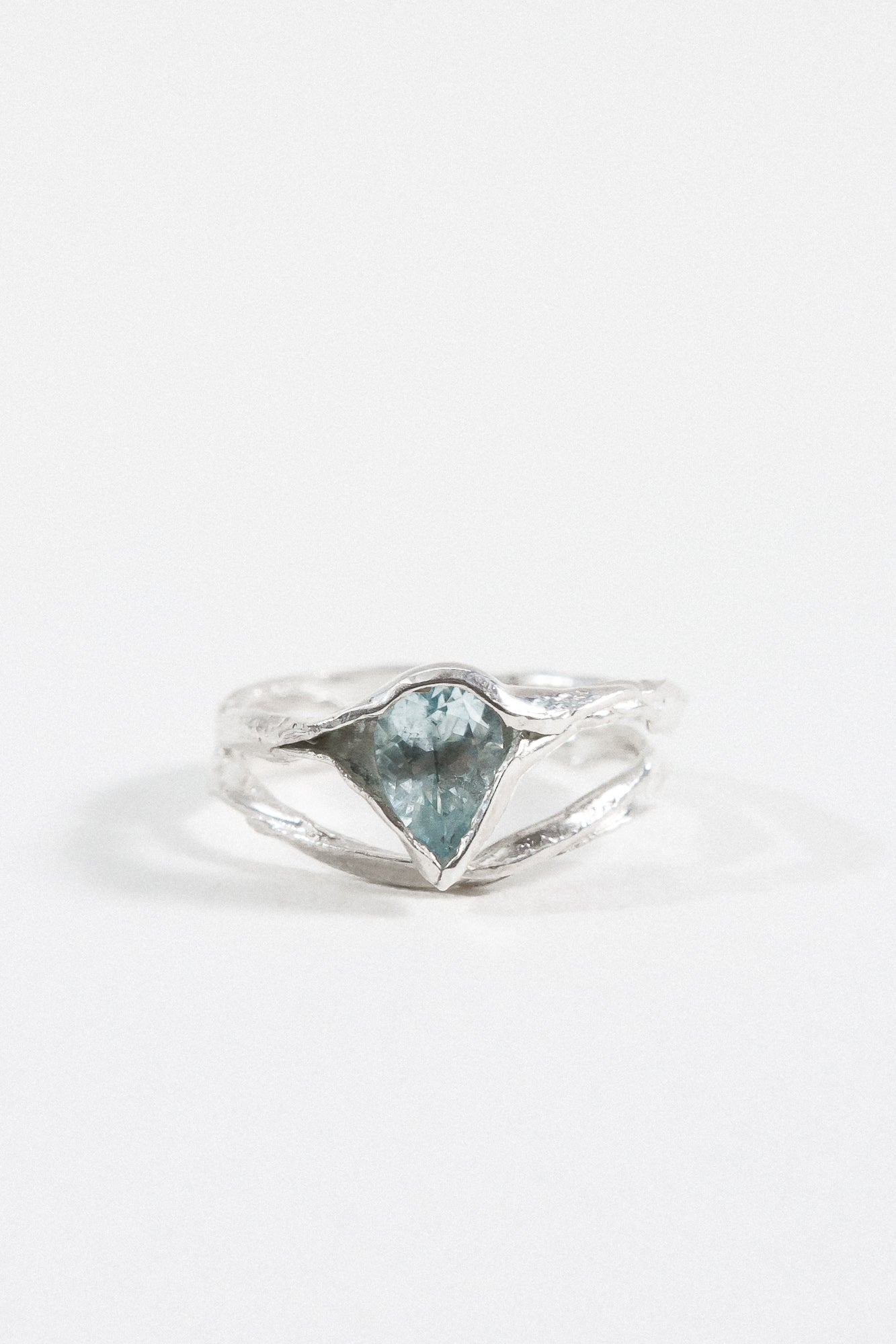 Anillo de plata esterlina con una piedra de aguamarina, mostrado de frente sobre fondo blanco.