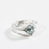 “Vista diagonal del anillo de plata esterlina con una piedra facetada de aguamarina.