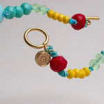 collar de cuentas de colores con cierre dorado sobre fondo claro.
