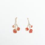Par de Aretes Agraz presentados sobre fondo blanco, resaltando su diseño inspirado en ramas y frutos.