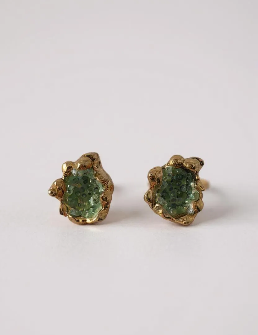 Par de aretes Topos Coca S con granulación de vidrio y pintura verde en engastes dorados, sobre fondo blanco.