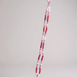 Collar Margarita extendido, con dije dorado en forma de flor y cadena de cristales rosa, fucsia y blanco.