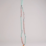 Collar Naranja extendido verticalmente sobre fondo blanco, mostrando la cadena completa de cuentas en verde menta y rosa y el colgante de media luna naranja en la parte inferior.