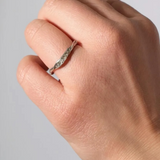 Anillo de plata con diamantes de laboratorio en un dedo, mostrando cómo luce puesto en la mano.
