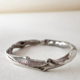 Vista superior del anillo de plata hecho a mano con diamantes de laboratorio, sobre fondo blanco.