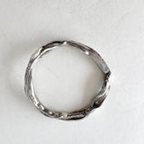Anillo de plata visto desde arriba, mostrando su forma circular y textura orgánica con pequeños diamantes de laboratorio.