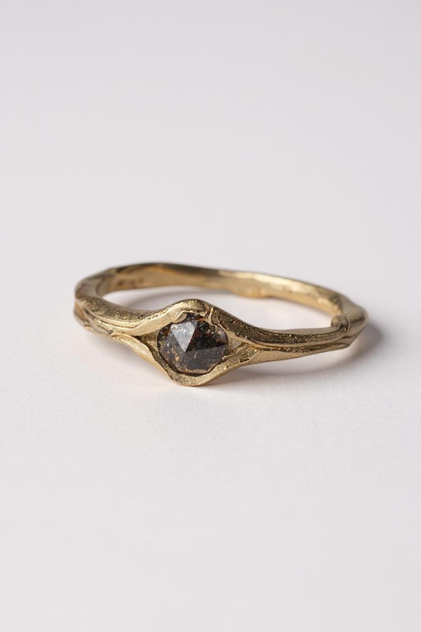 Vista frontal lateral del anillo de oro amarillo 10k con diamante sal y pimienta sobre fondo blanco.