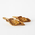 Disposición plana de dos Aretes Lechuga variante Mustard en bronce bañado en oro, pintados a mano en rust con granulación de vidrio, sobre fondo blanco.