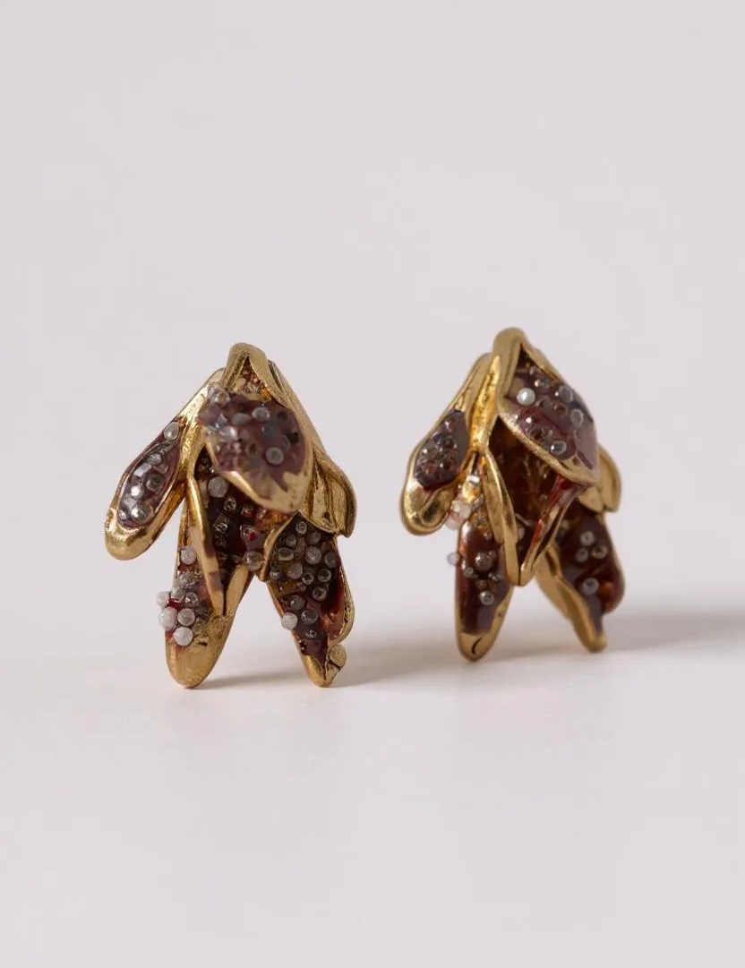 Par de aretes topos Nebula Mini en bronce bañado en oro, pintados a mano en  rust y con granulación de vidrio, sobre fondo blanco.