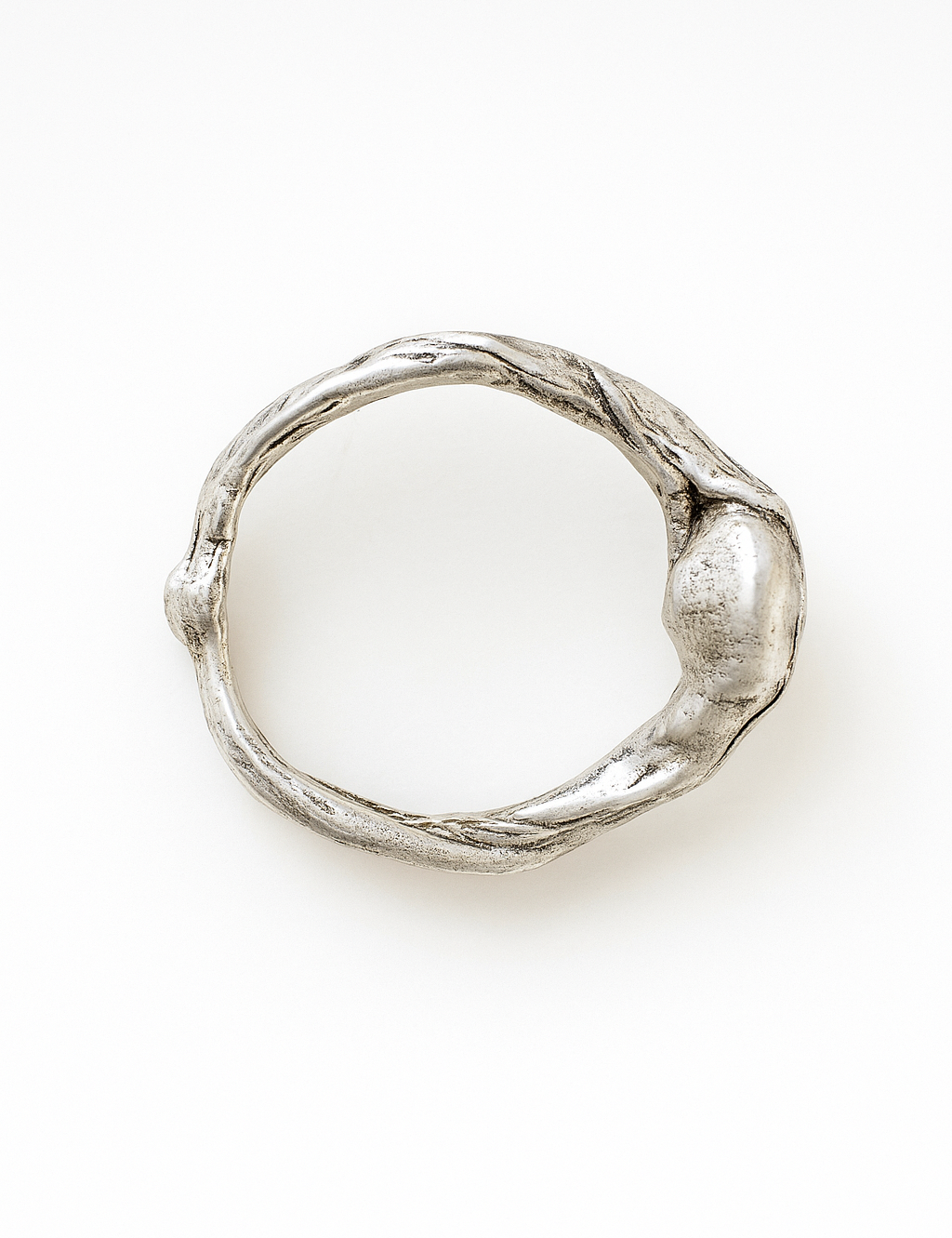 Anillo de plata esterlina con piedra del sol puesto en una mano, fotografiado sobre fondo gris claro