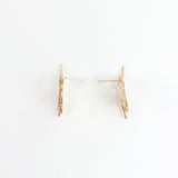 Vista lateral de los Topos Rosa Salvaje mostrando poste y volumen de la pieza en bronce bañado en oro.