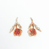 Topos Rosa Salvaje Roja en bronce bañado en oro con pétalos orgánicos y granulación coral, sobre fondo blanco.