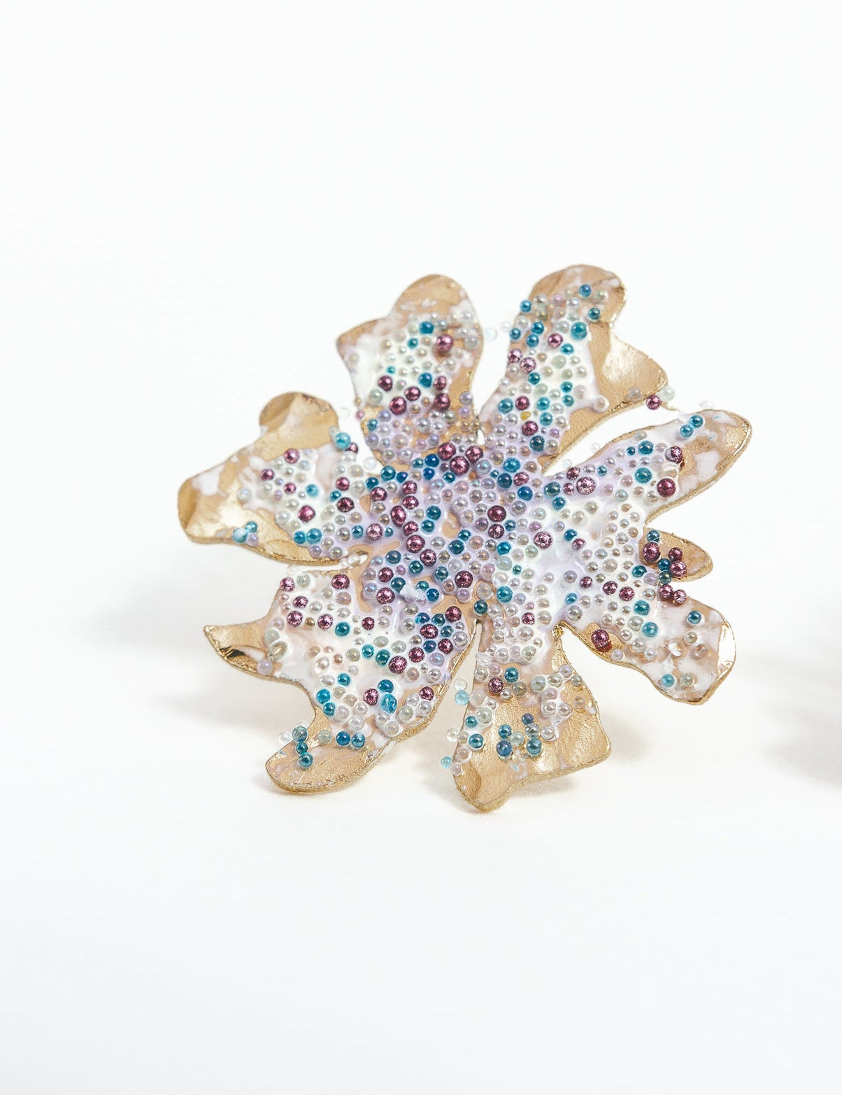 Detalle cercano de los topos Trébol Silvestre, mostrando la superficie texturizada y la granulación de vidrio multicolor