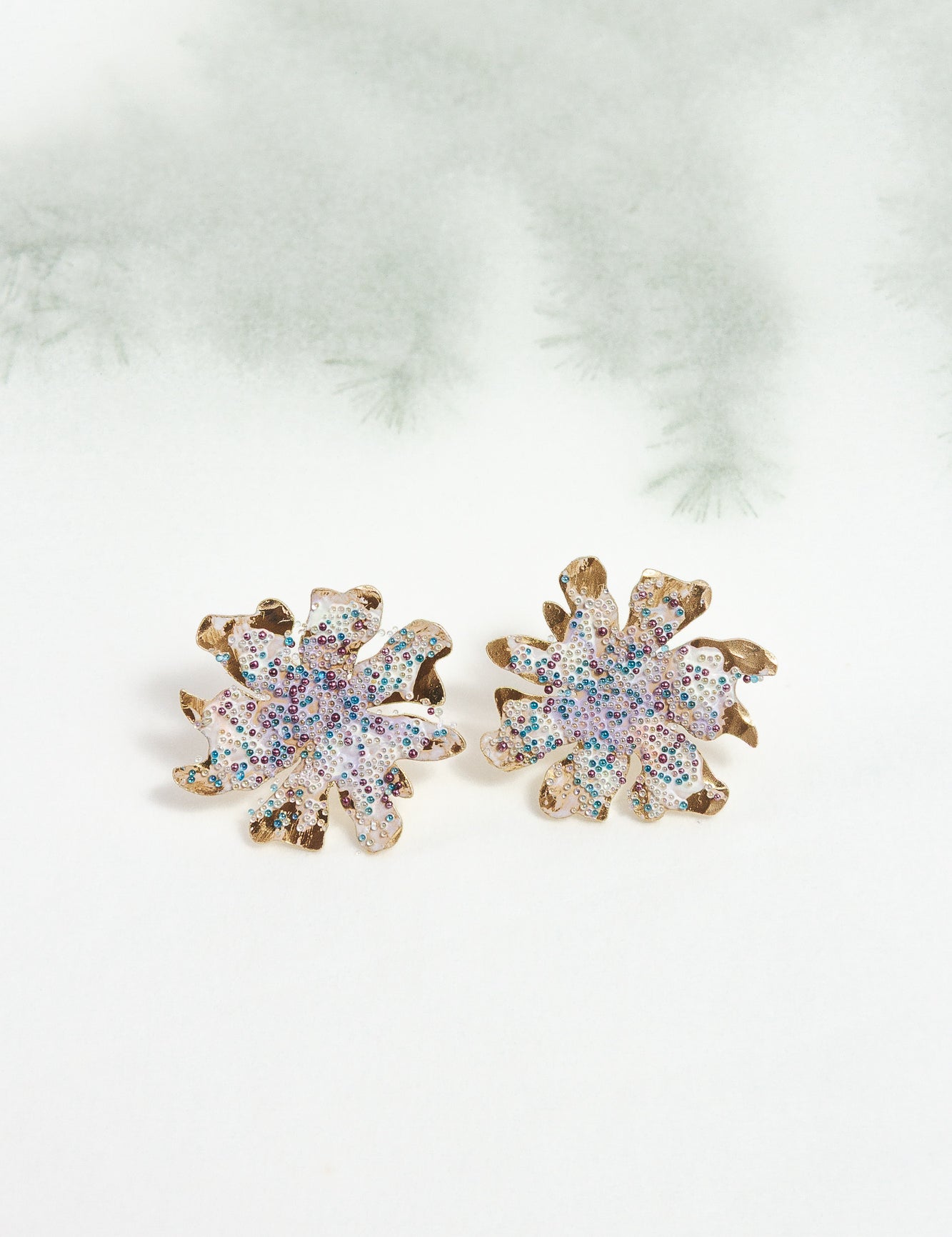 Topos Trébol Silvestre sobre fondo claro con ramas difuminadas, resaltando su diseño botánico y acabado artesanal.