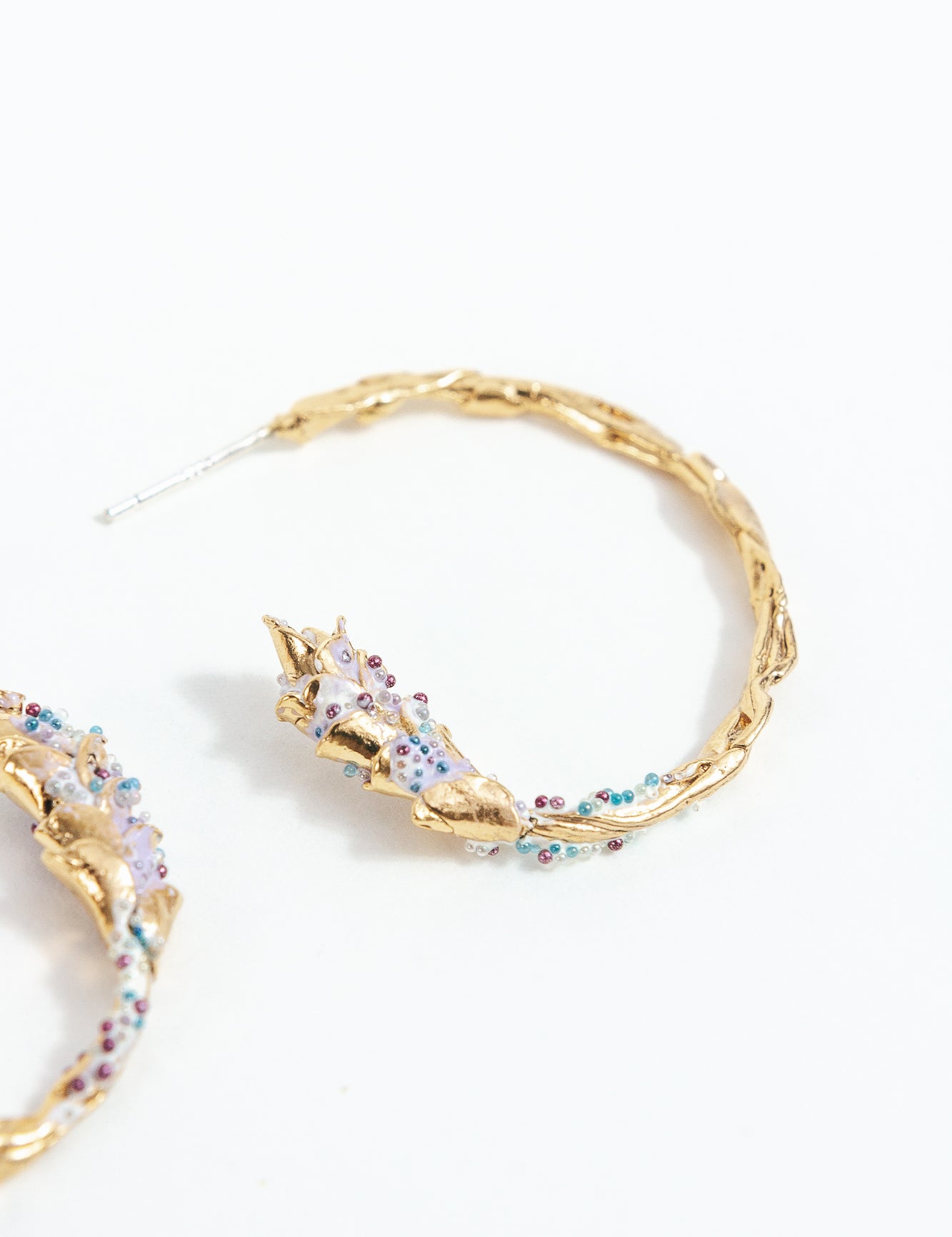 Detalle cercano de la Candonga Espiga lavanda, mostrando pintura artesanal y granulación de vidrio en tonos lilas y turquesa.