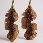 Par de aretes Hojas de Plátano en bronce bañado en oro pintado a mano en rust detalle de granulación de vidrio, sobre fondo blanco.